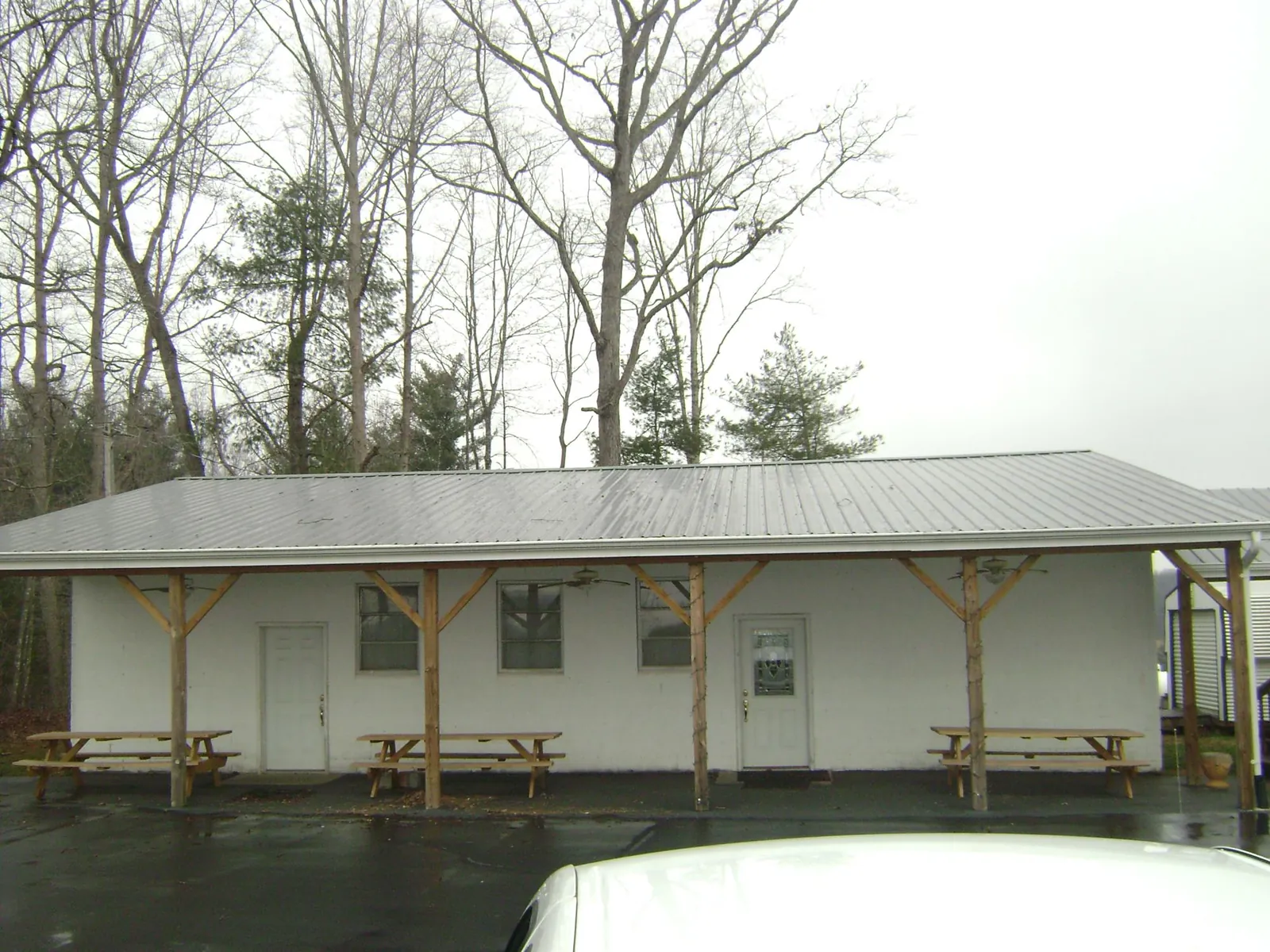 Gray metal roof over a block building with a timber post porch in Rocky Hill
